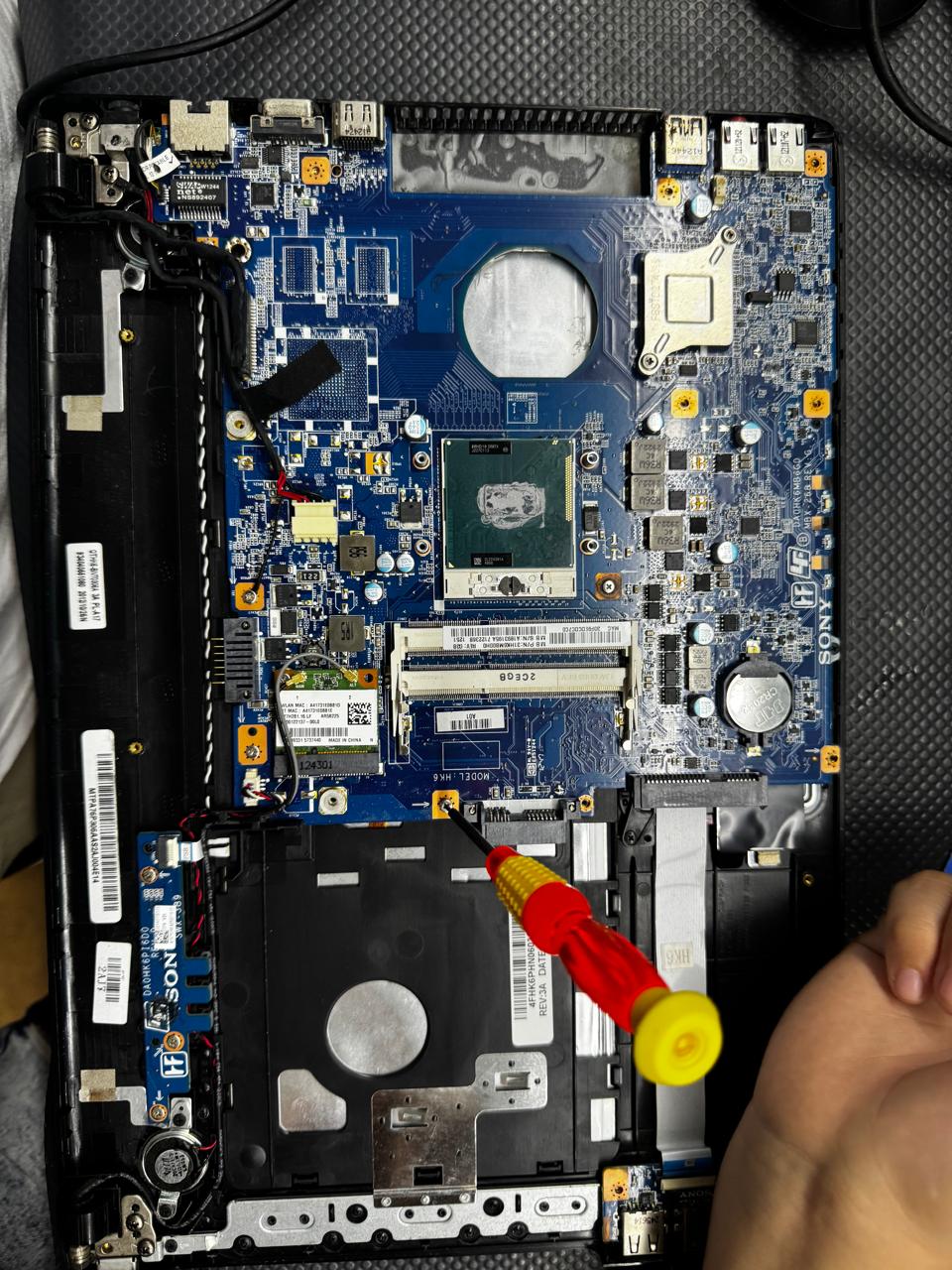 Laptop abierta mostrando placa madre en diagnóstico